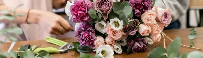 A flower arrangement being made on a table.